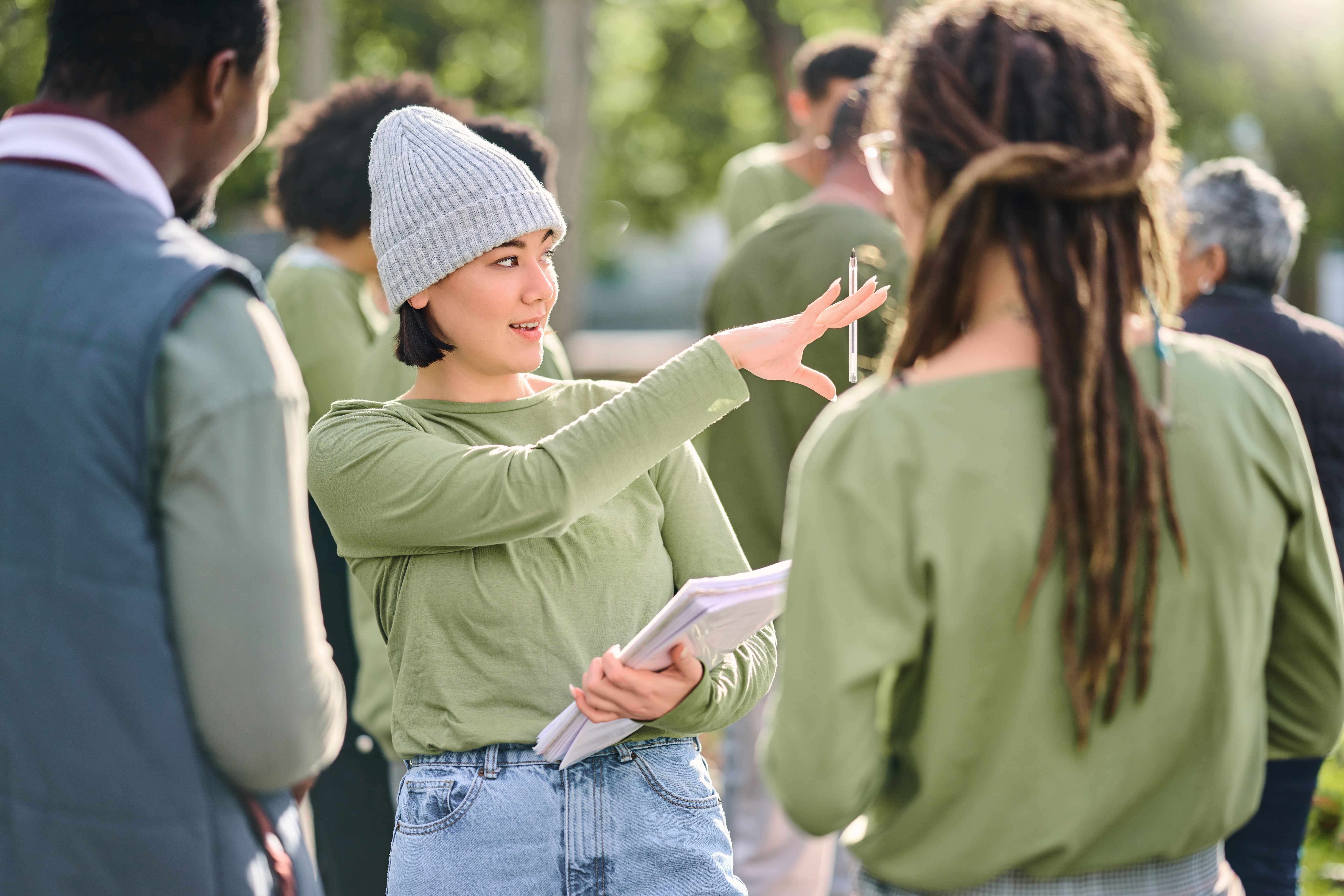 Young volunteer leader coordinating community group outdoors